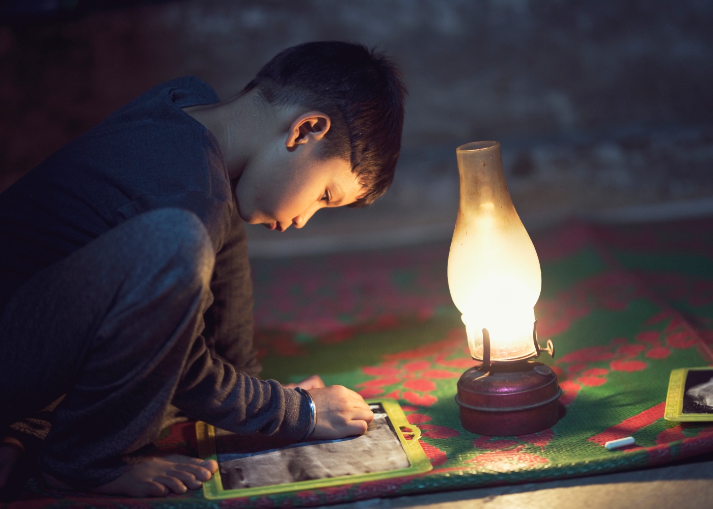 criança a brincar à luz de lanterna de óleo