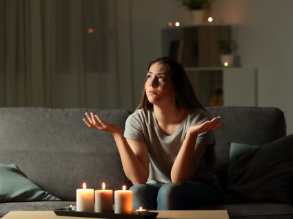 mulher em casa sem eletricidade à luz das velas