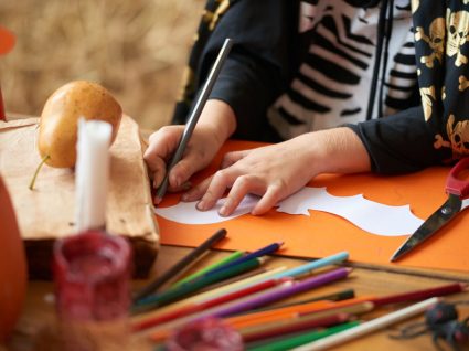 criança a preparar itens decorativos de halloween na escola