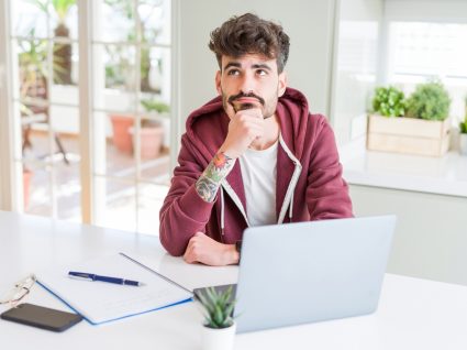 jovem estudante ao computador com ar pensativo