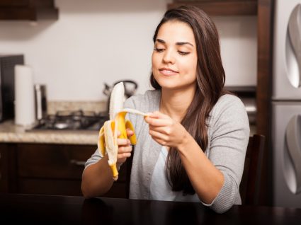 Mulher a comer banana à noite