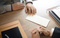 pessoas a analisar documento de despedimento ilícito