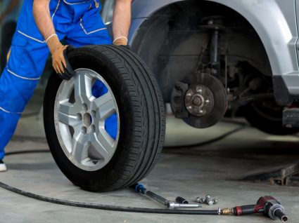 mecânico a trocar os pneus do carro