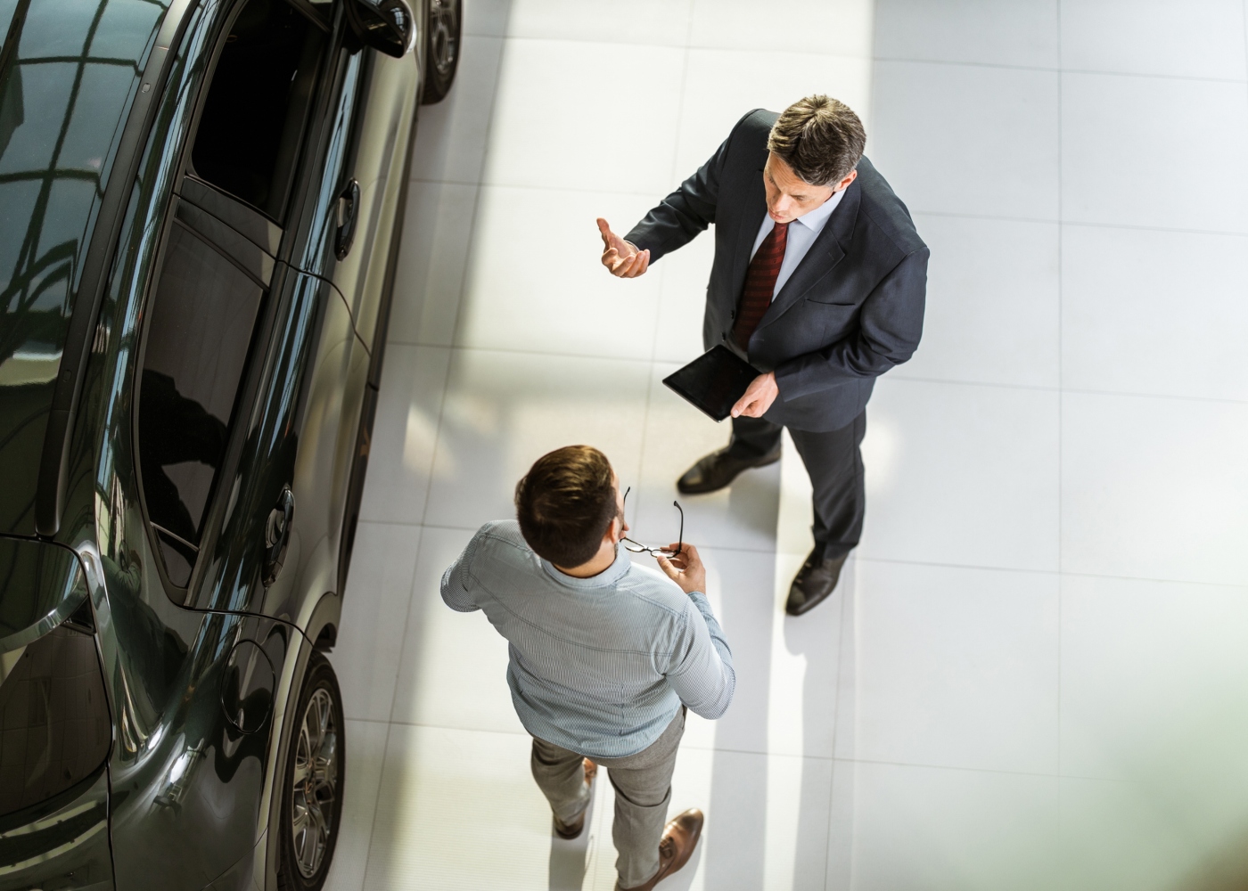 Homem num stand automóvel a conversar com o vendedor