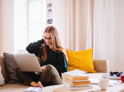 jovem com computador e livros a ver como mudar de curso