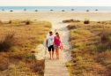 casal a caminhar na praia