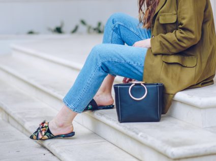 mulher sentada em escadaria com sapatos mules