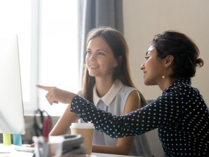 duas jovens a trabalhar num computador