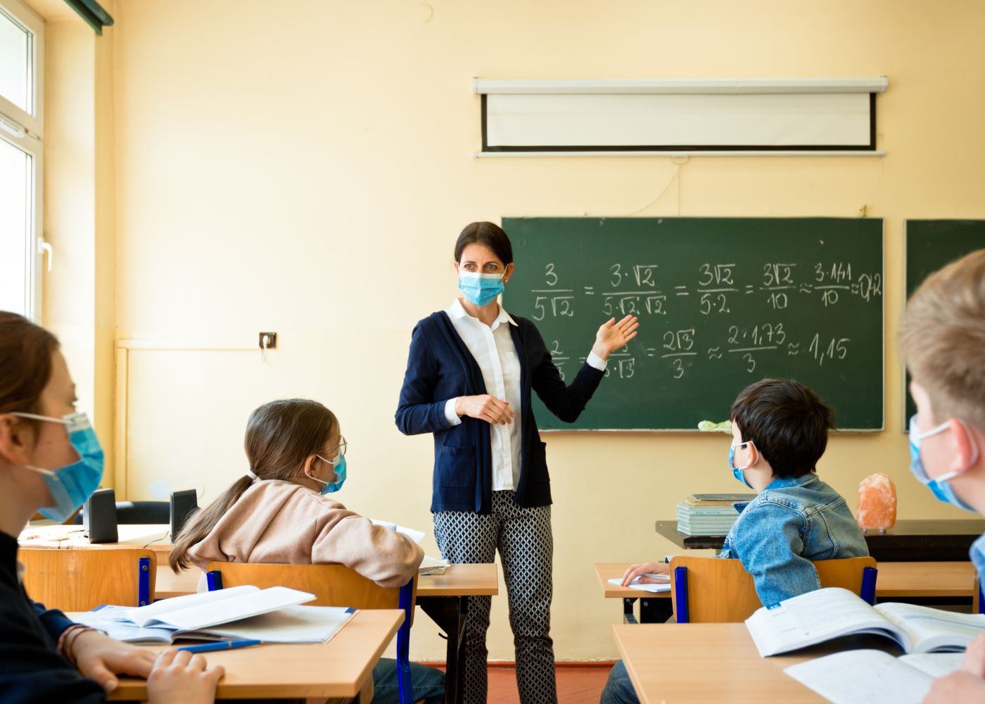 professora na sala com máscara a dar aulas e mostrar a importância dos professores