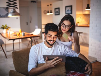 casal a ver lojas online para comprar móveis no tablet