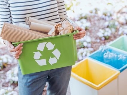 mulher a segurar caixote de reciclagem com cartão