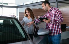 mulher a ver veículo antes de comprar carro usado a um particular