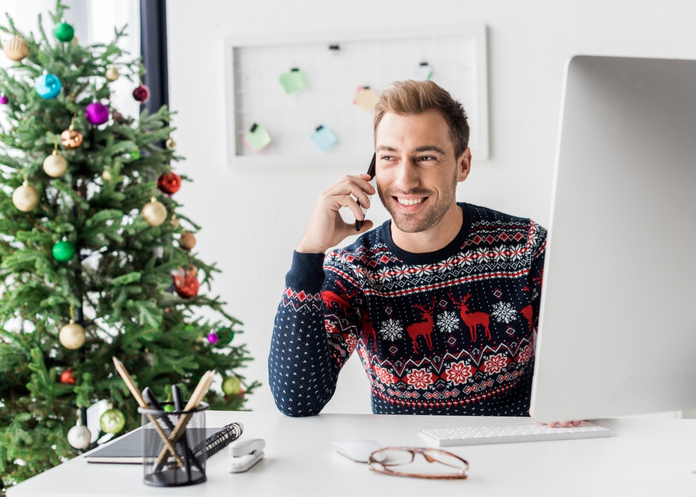 jovem com camisola de natal a trabalhar num escritório