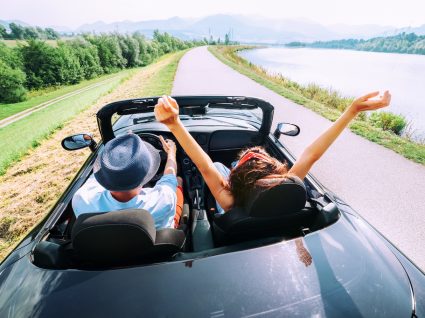 casal a andar num carro descapotável