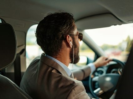 homem a conduzir com auriculares