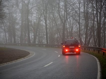 carro a circular com nevoeiro e tempo de inverno