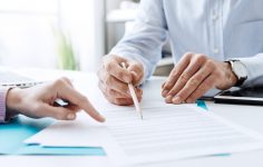 duas pessoas a analisar documentos do subsídio social de desemprego inicial