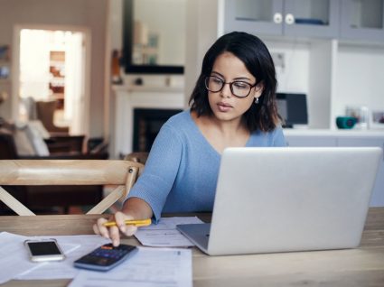 Mulher a calcular a percentagem de retenção na fonte sobre o seu salário