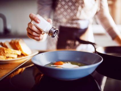 Mulher a usar sal no cozinhado