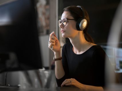 mulher com fones em teletrabalho