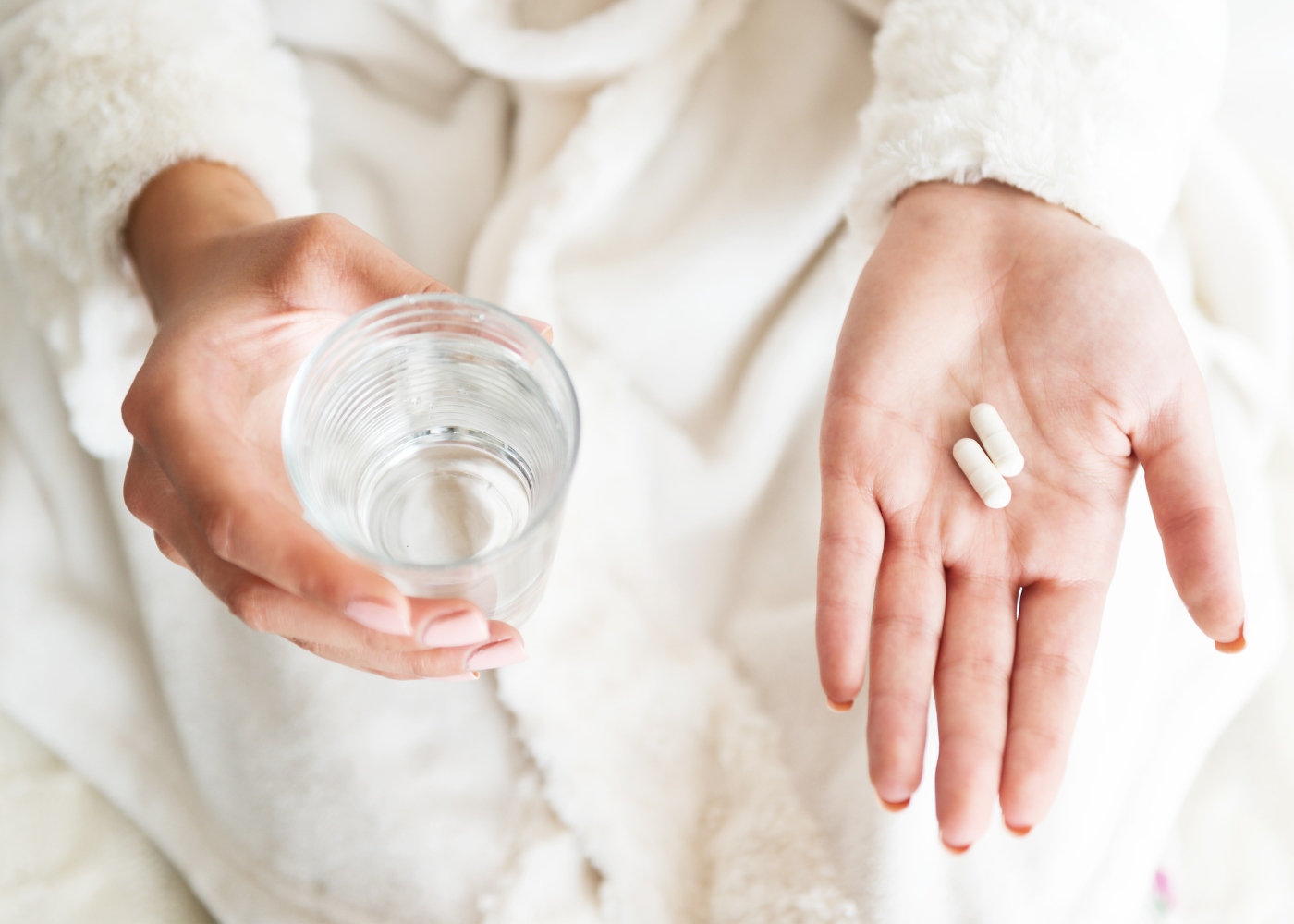 mulher com medicamentos na mão para tomar