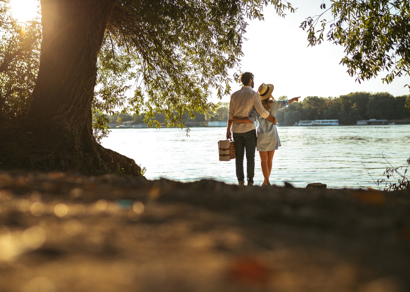 Casal a fazer um piquenique junto a praia fluvial