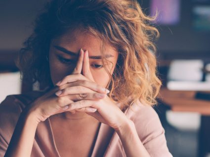 mulher com mãos na cara a sofrer de depressão de domingo