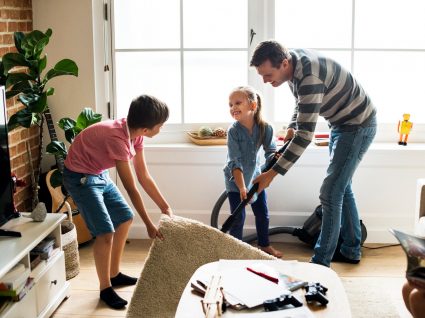 pai e filhos a aspirar a sala