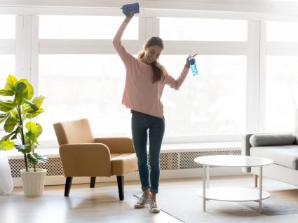 mulher com hábitos das pessoas que tem sempre a casa limpa a arrumar a sala