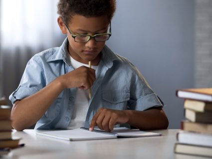 rapaz a tentar concentrar-se para fazer trabalhos de casa