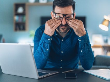 homem frustrado no trabalho com síndrome do impostor