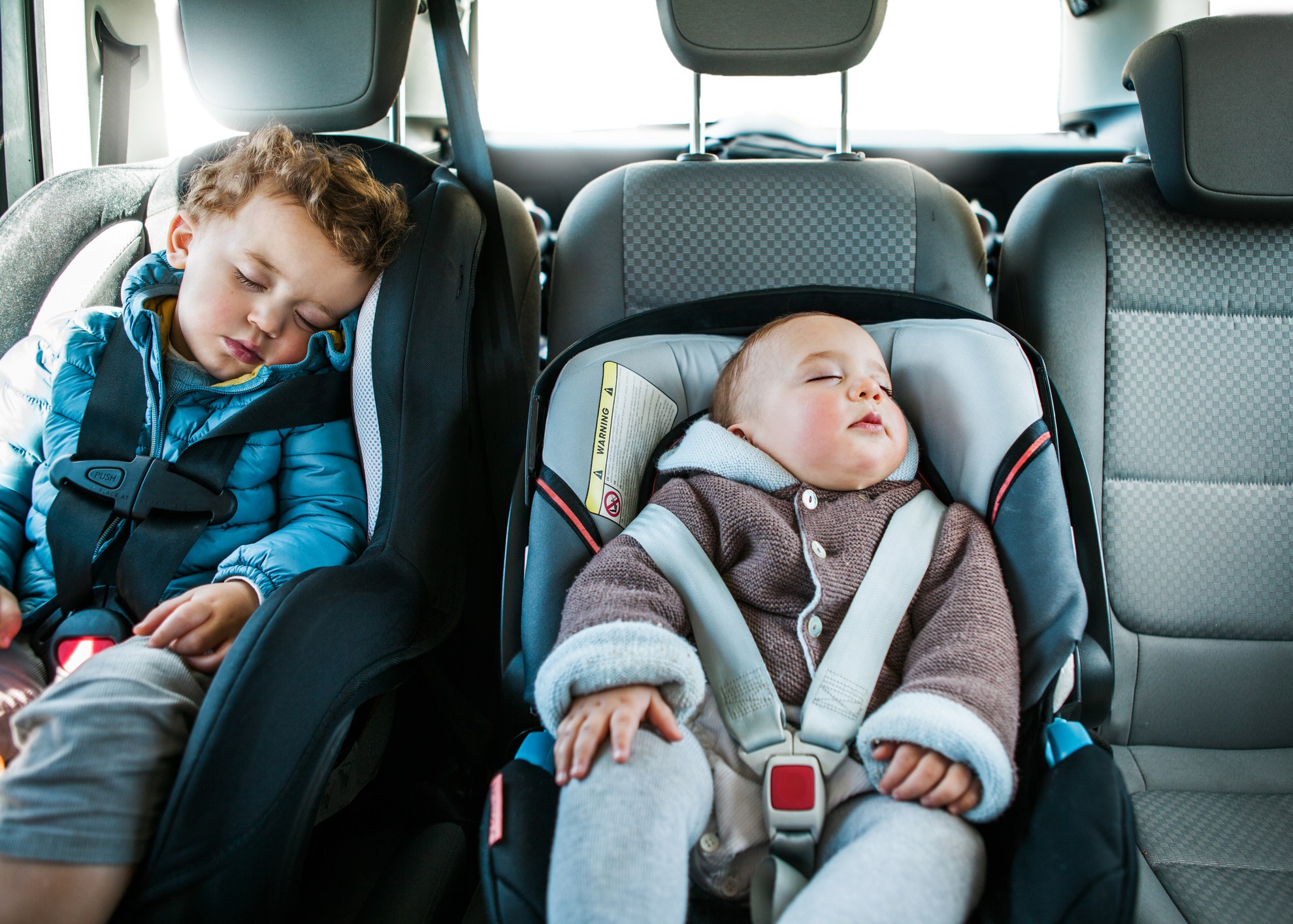 bebes num carro sentados em cadeirinhas