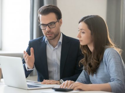 orientador no computador a explicar as funções à estagiária