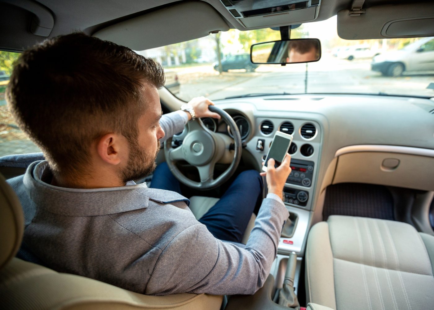 homem a usar telemóvel ao volante