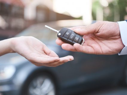 homem a entregar chave de carro a mulher