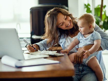 mãe solteira em teletrabalho com criança ao colo