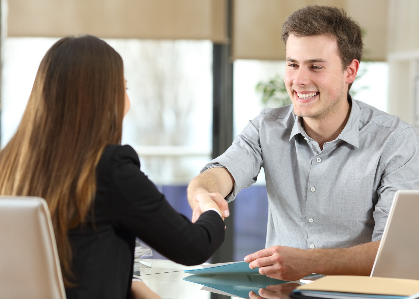 jovem a cumprimentar recrutadora na entrevista