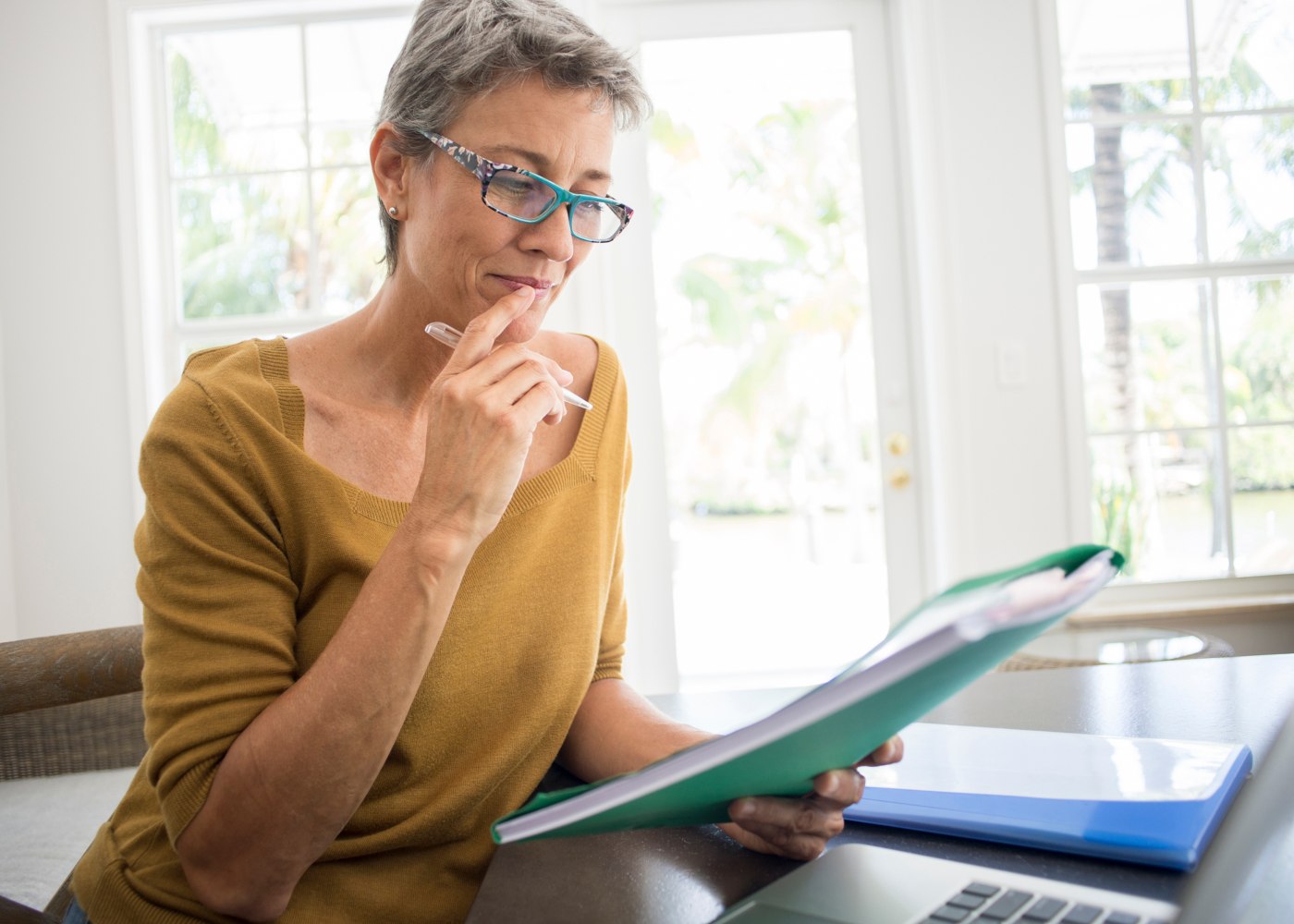 mulher ao computador e a analisar documentos