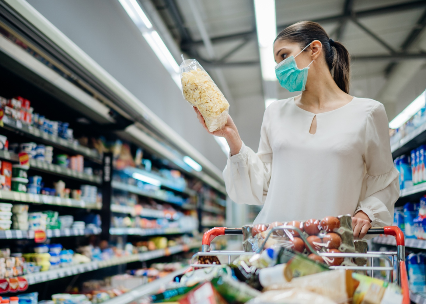 Mulher com máscara a fazer compras no supermercado