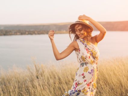 jovem com vestido estampado floral no meio da seara