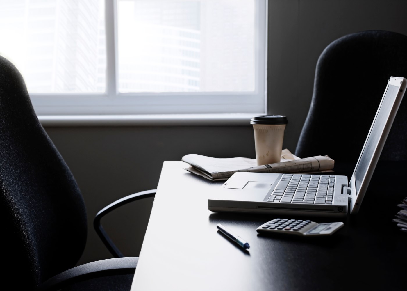 sala de trabalho com computador na mesa mas sem ninguém