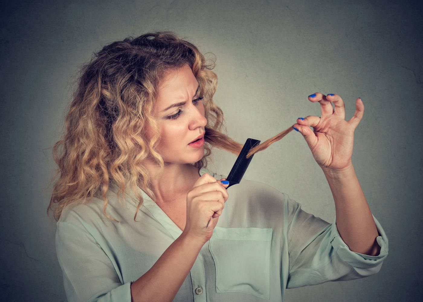 Mulher a pentear-se e com queda de cabelo