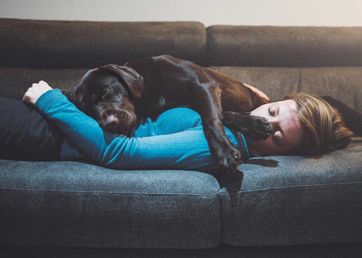 Mulher a dormir com cão no sofá