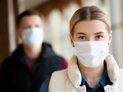 Mulher a usar máscara de proteção em espaço público