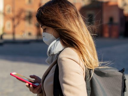 Mulher na rua com máscara de proteção