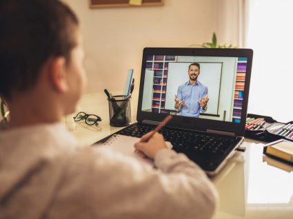 papel dos professores na pandemia: aluna a assistir a uma aula pelo computador com professor