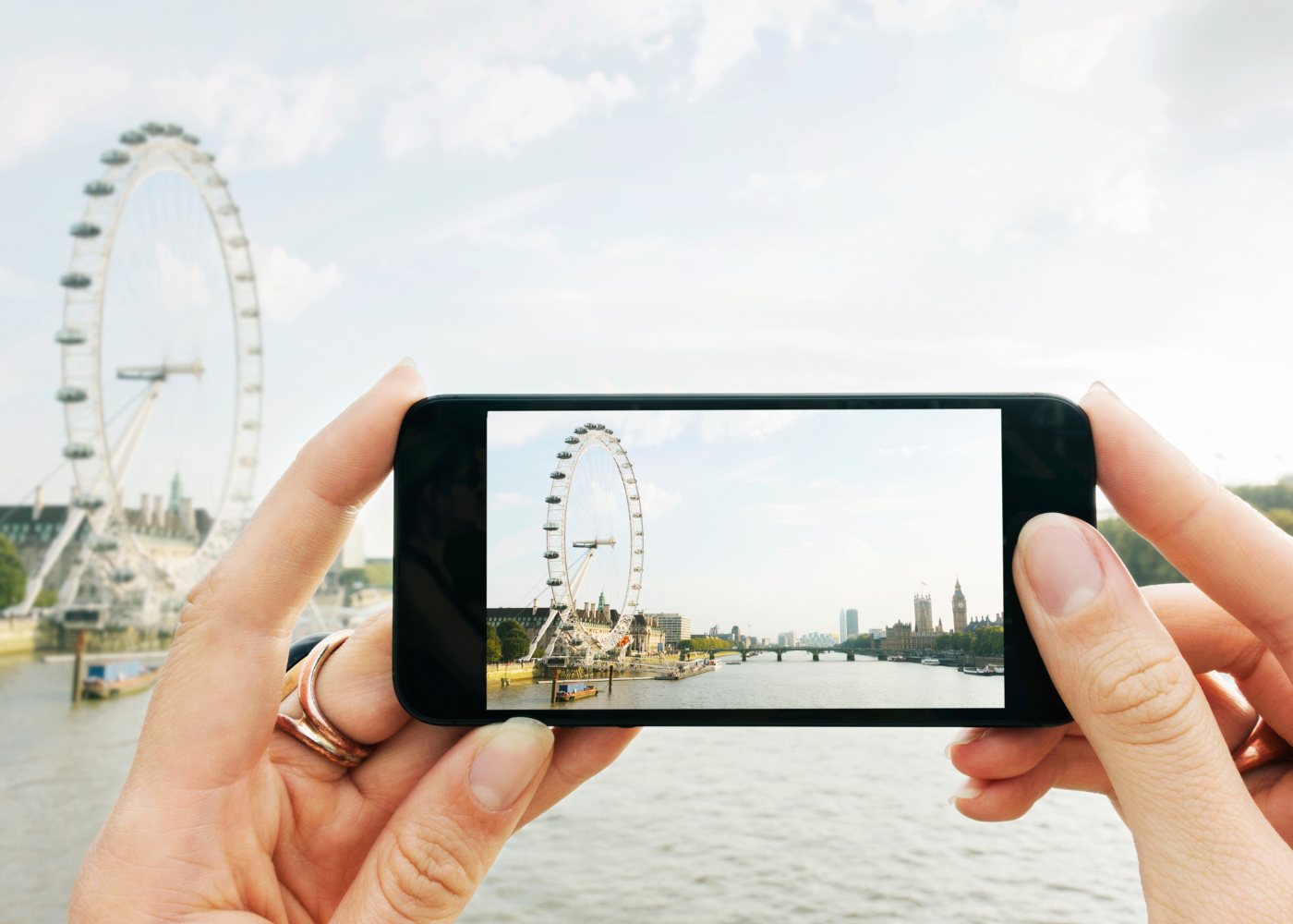 Mulher com smartphone a fotografar o London Eye