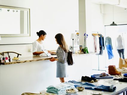 Mulher a trocar artigos numa loja de roupa