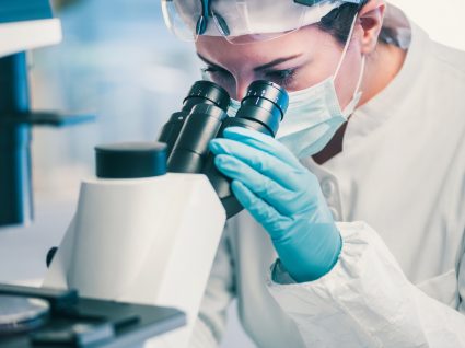 Cientista a analisar comportamento de vírus ao microscópio
