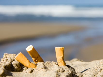 Beatas de cigarro na areia da praia